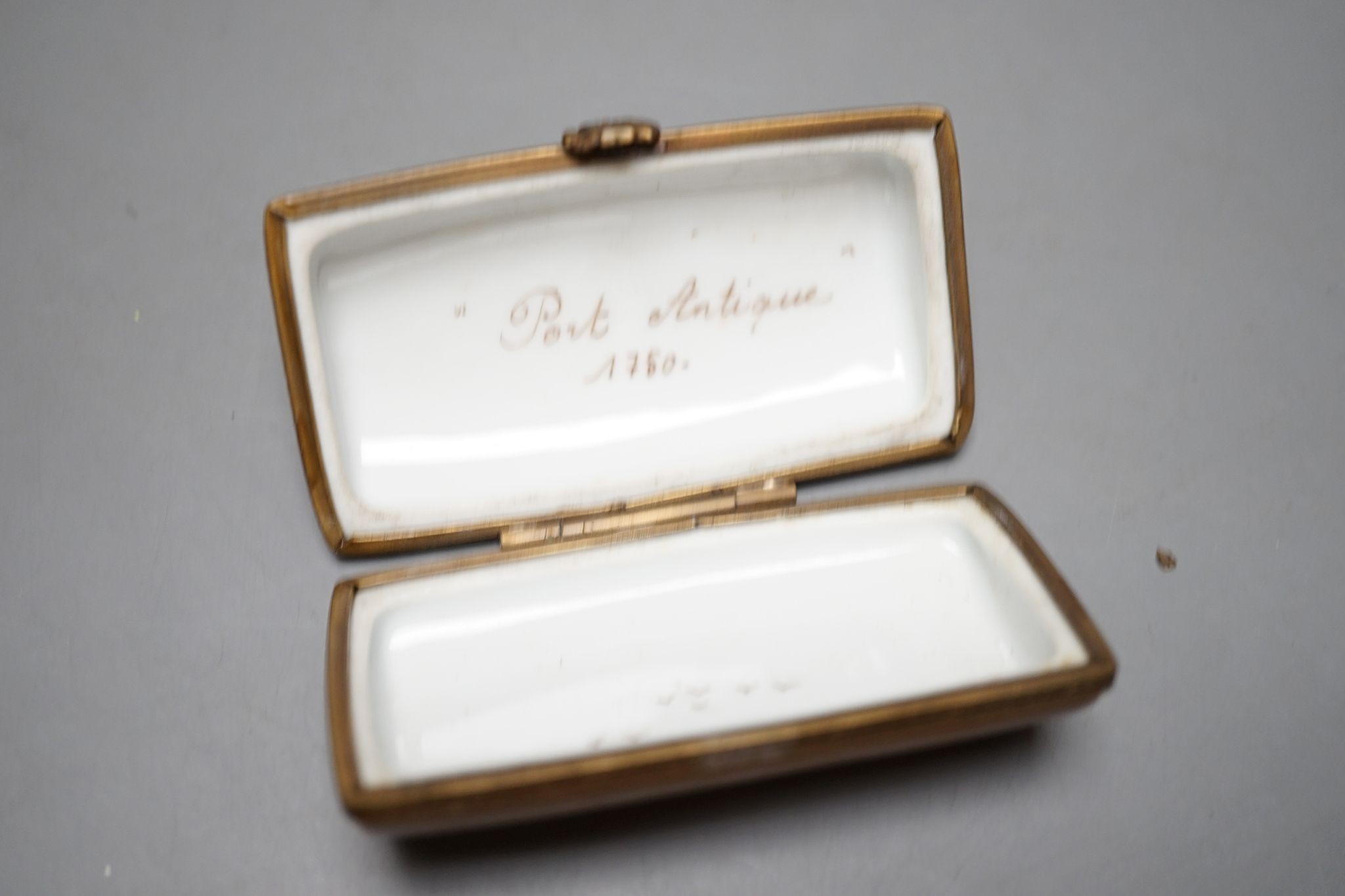 A Russian oval lacquered box, 10cm., and a porcelain box painted with ships approaching harbour